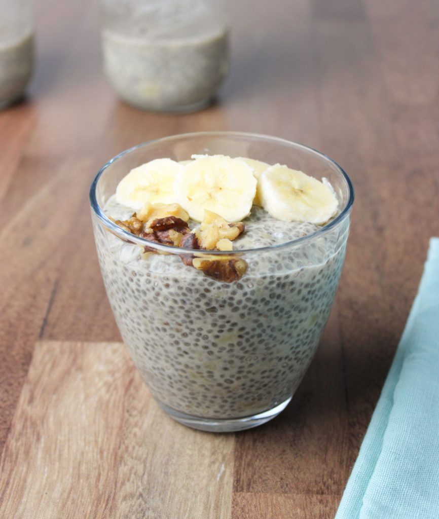 Glass with chia pudding and banana slices and walnuts.