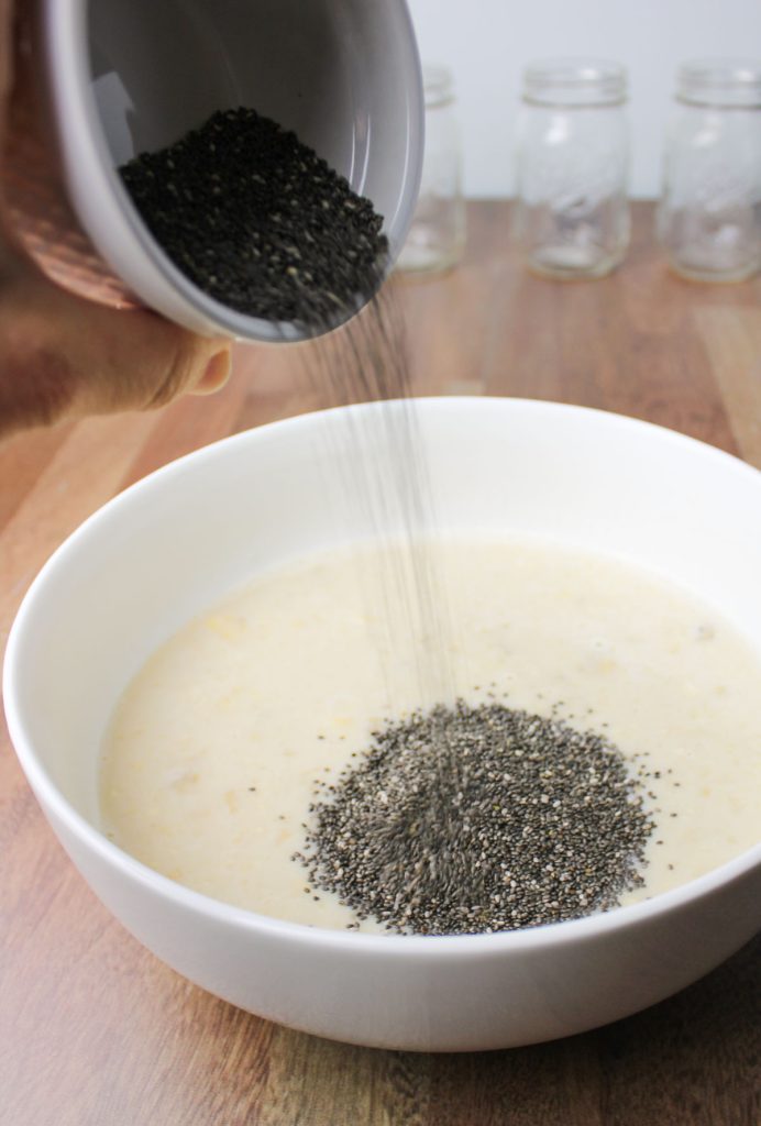 Chia seeds being poured into a bowl.