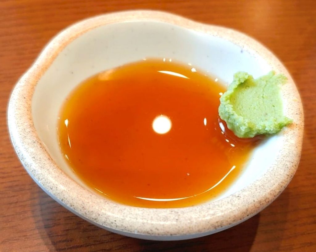 White dish with soy sauce and wasabi.