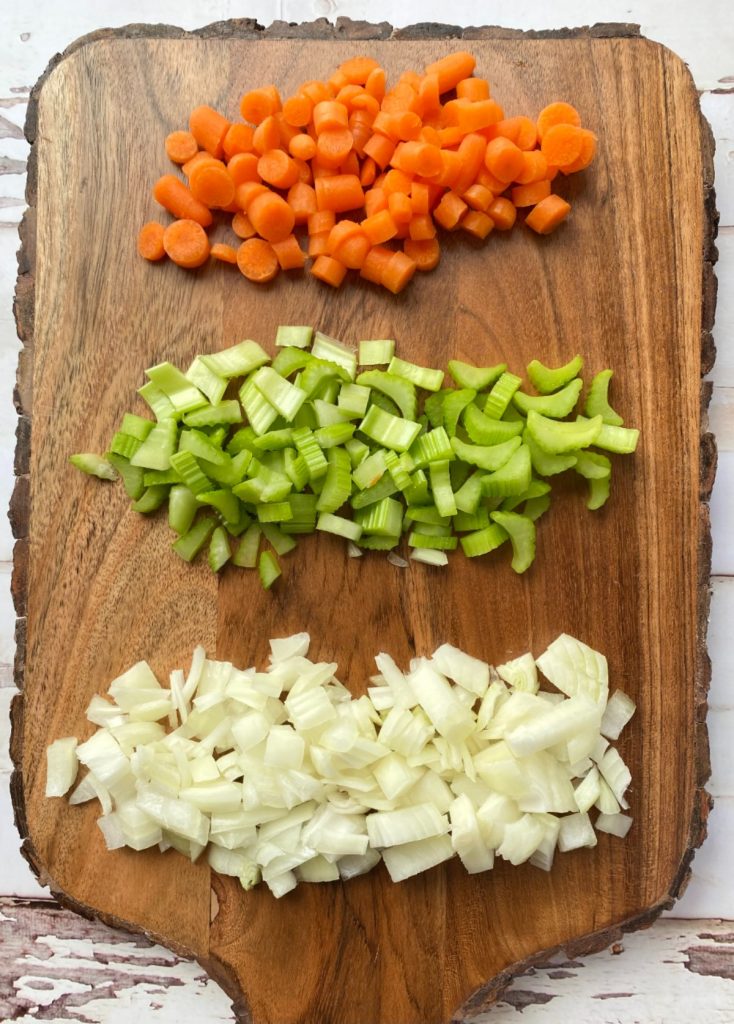 carrots, celery, and onions on cutting board