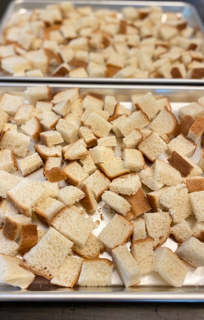 bread cubes on baking sheets.
