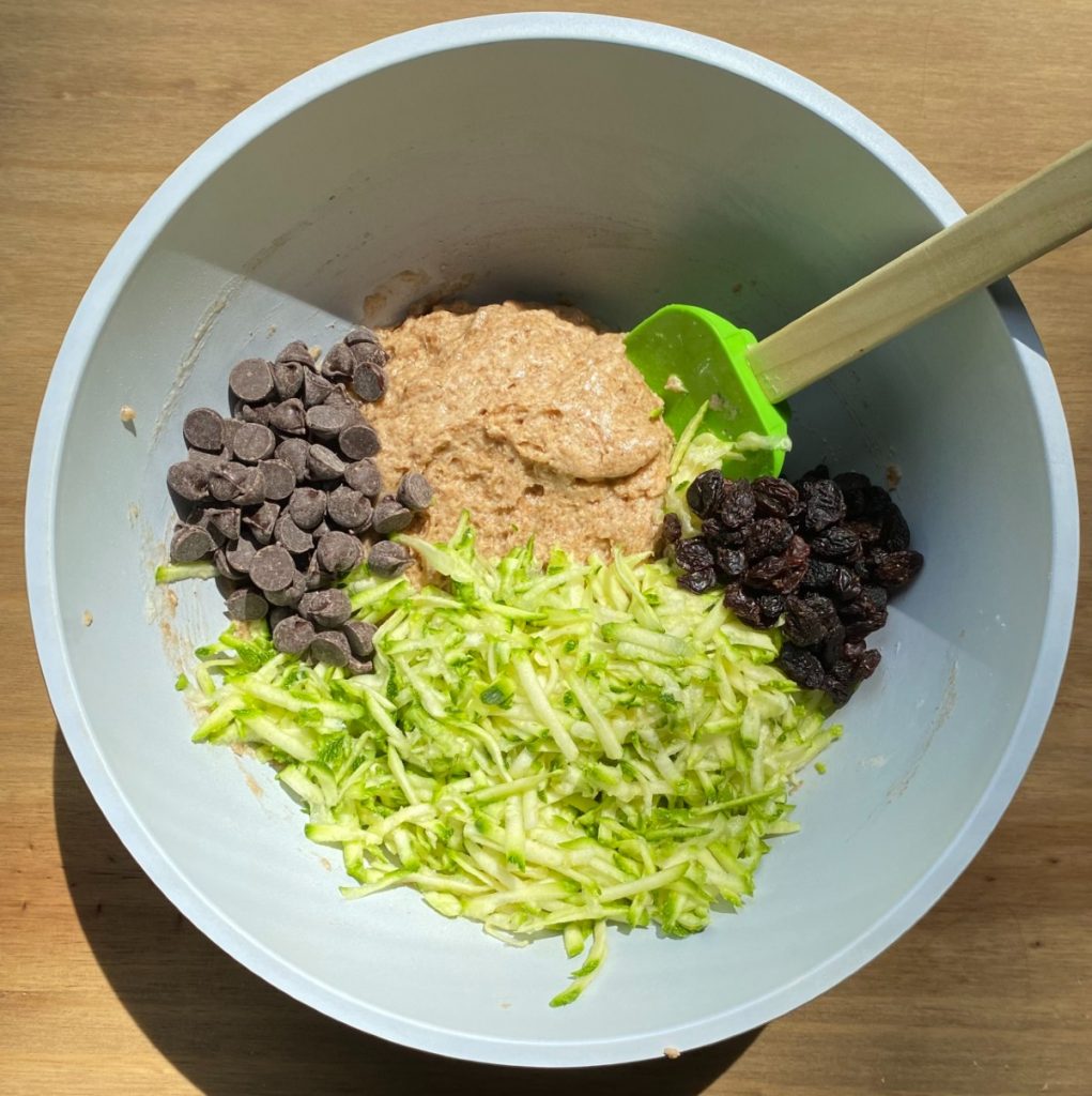 bowl with batter, zucchini, chocolate chips and raisins.