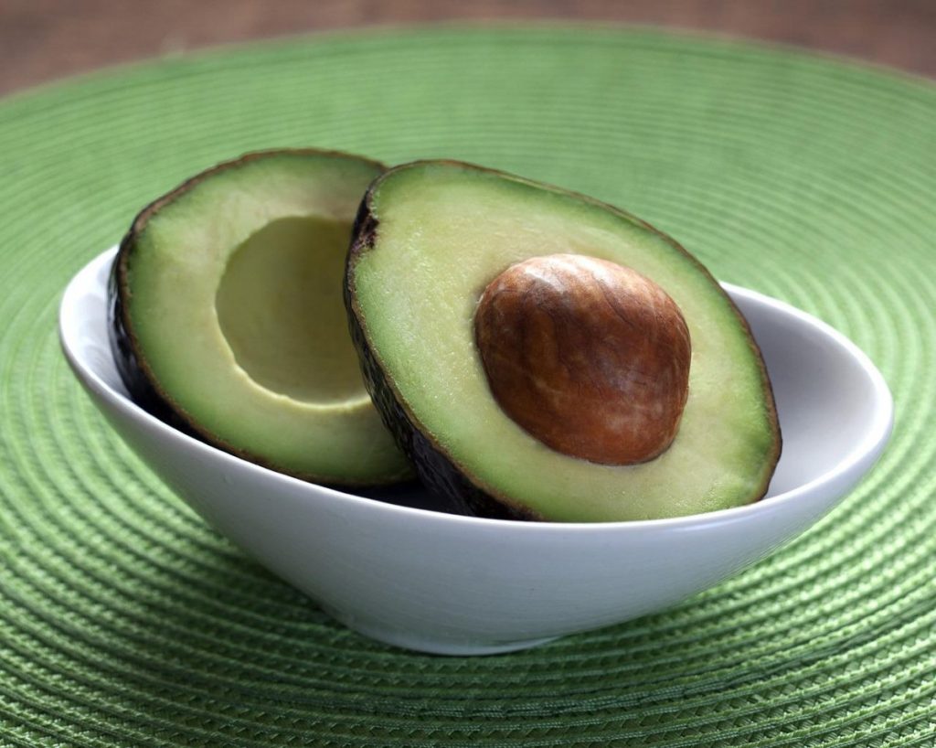 avocado cut in half in a bowl.