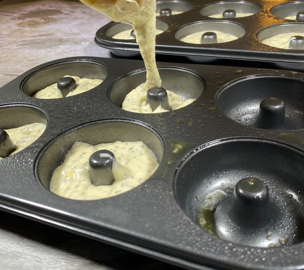 donut batter pouring into donut pan.