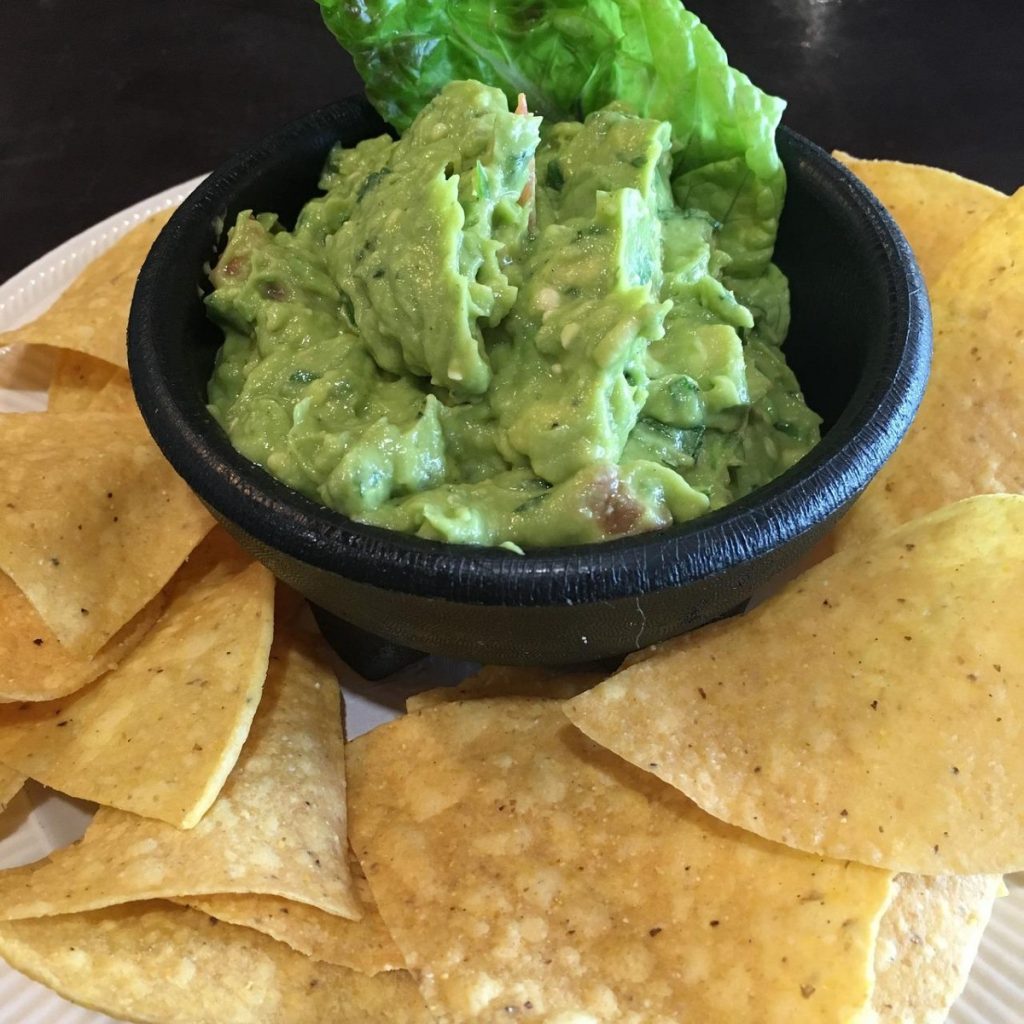 plate of chips with guacamole.