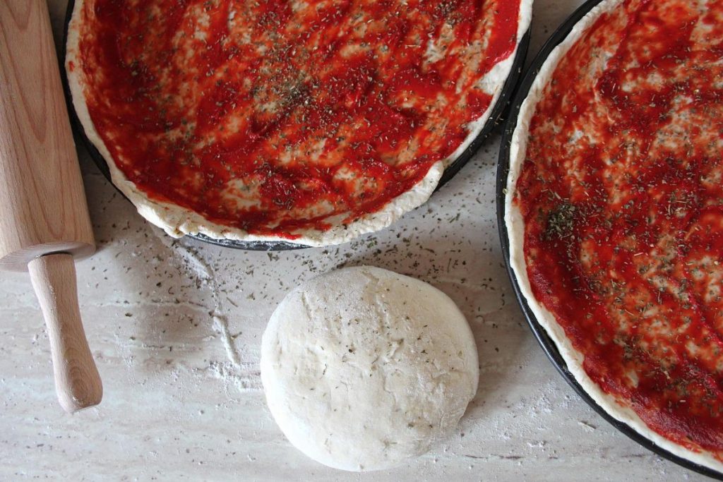 pizza dough with tomato sauce on it.