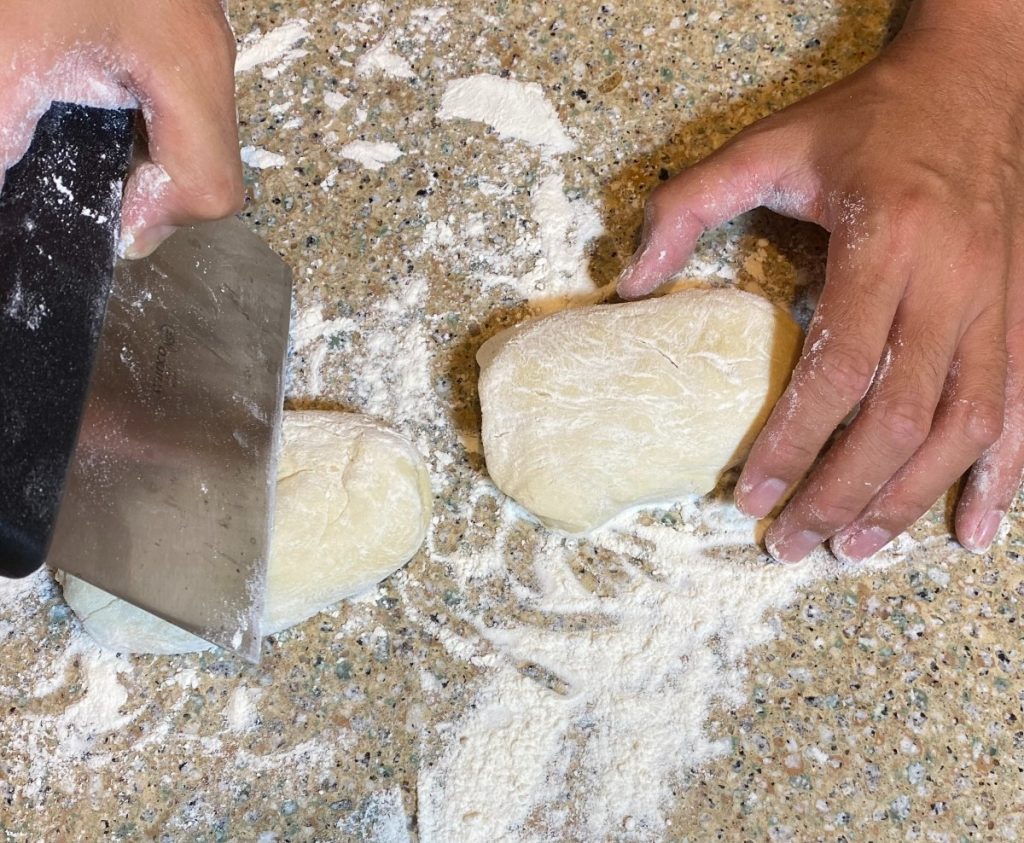 dough being cut into pieces.