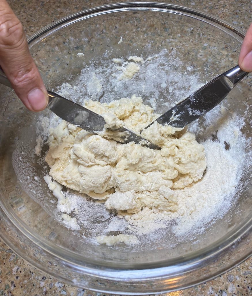 dough being mixed with 2 knives.