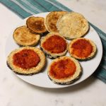 plate of baked eggplant slices with tomato sauce.