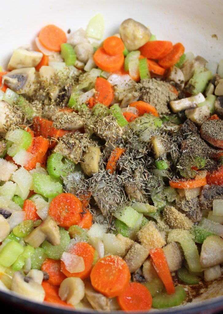 vegetables in a pot with dried herbs sprinkled on top.