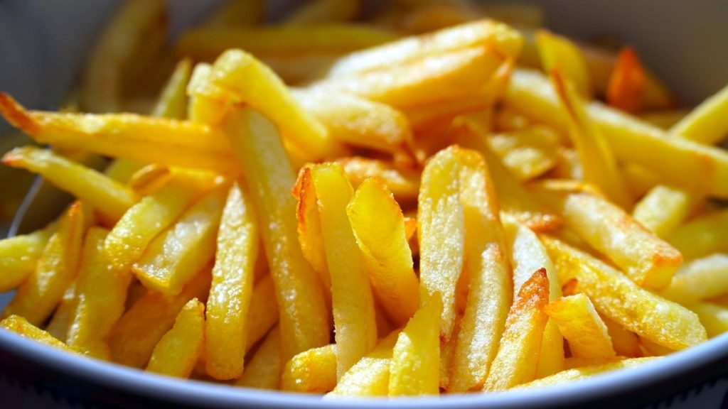 A close up of a plate of french fries.