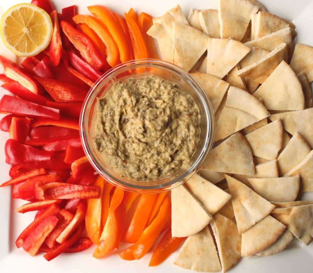 Platter with baba ganoush with peppers and pitas.