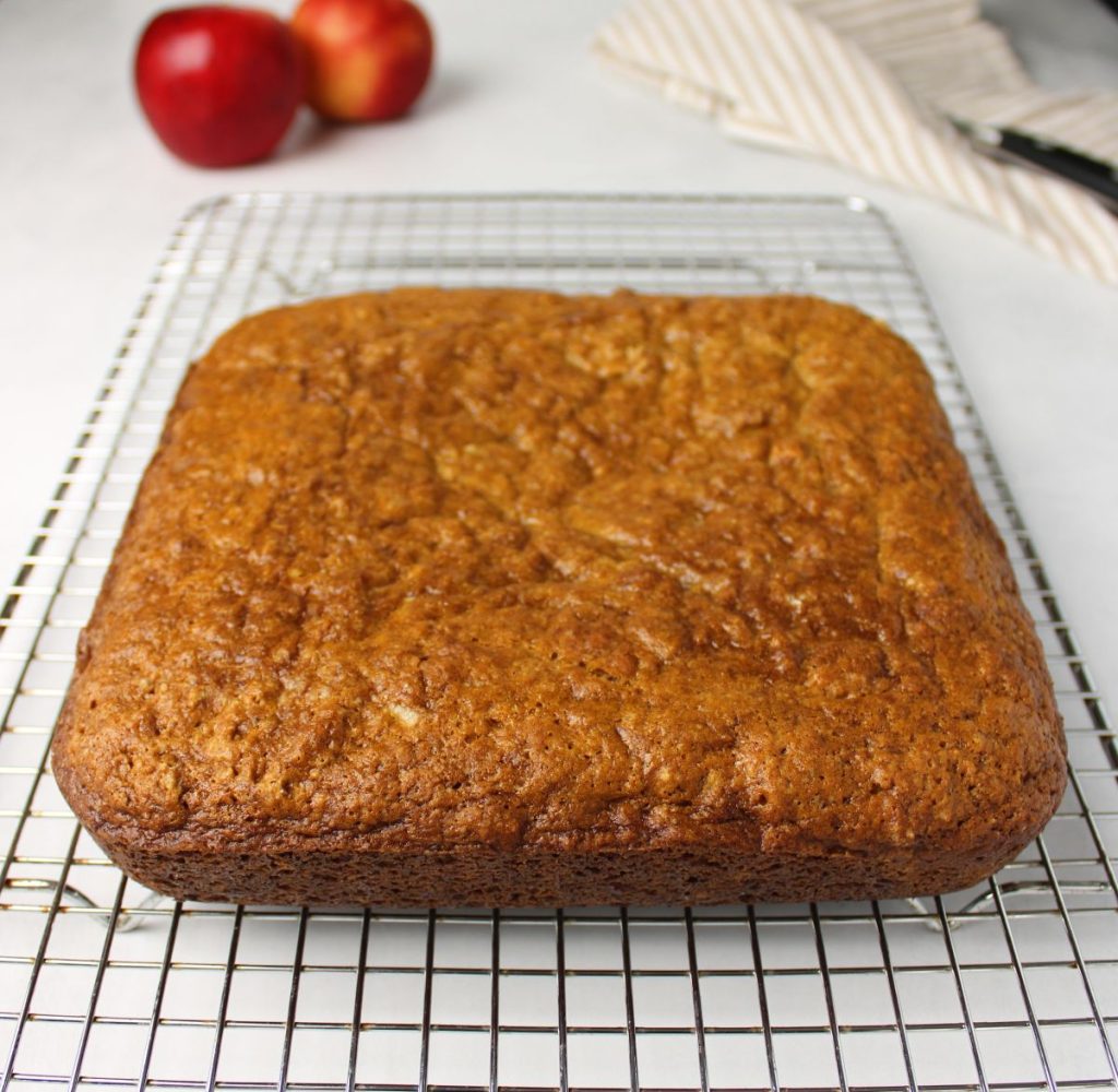 Baked applesauce cake on a cooling rack.