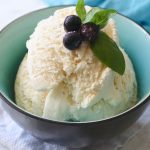 Vanilla ice cream in a bowl with blueberries.