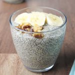 Glass with chia pudding, banana slices, and walnuts.